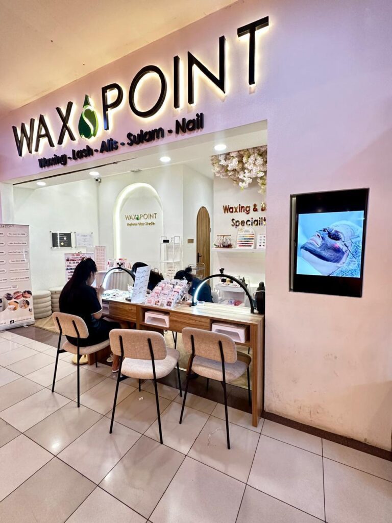 Bagian depan salon WaxPoint di dalam mal, dengan meja nail art dan tamu